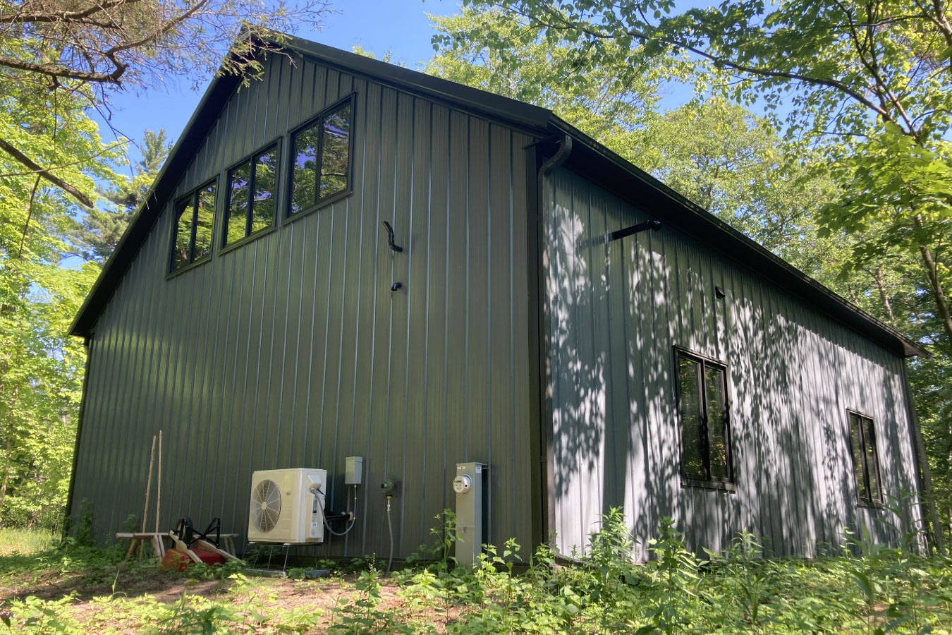 Shop with living quarters with steel siding in wooded setting