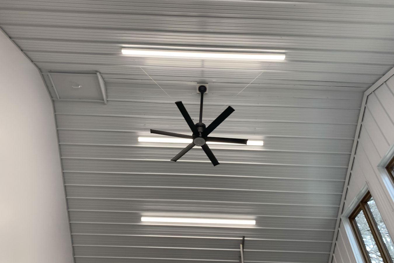 Shop with living quarters interior ceiling with LED lighting, ceiling fan, and windows for natural light