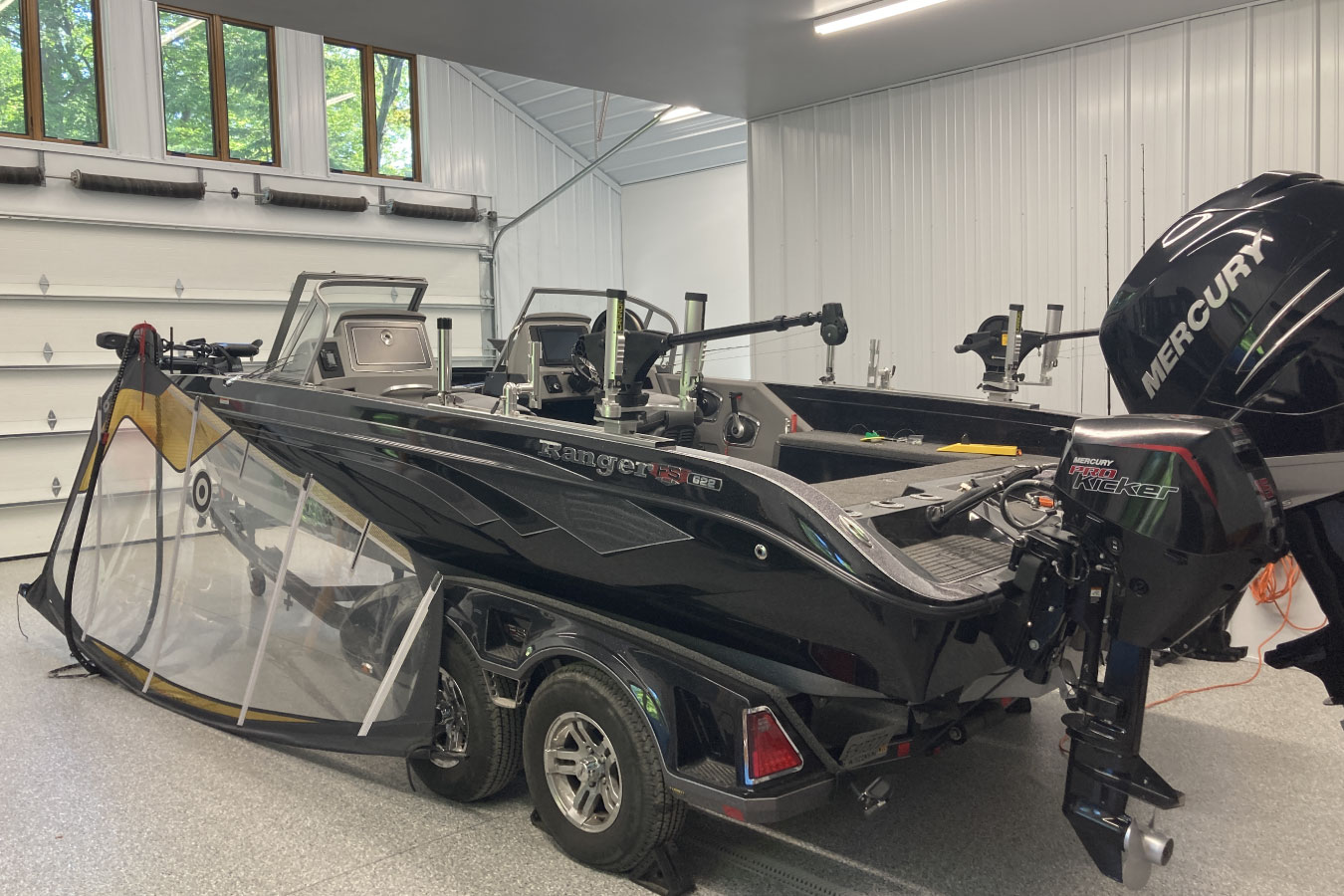 Shop with living quarters garage interior with boat storage, overhead door, and windows