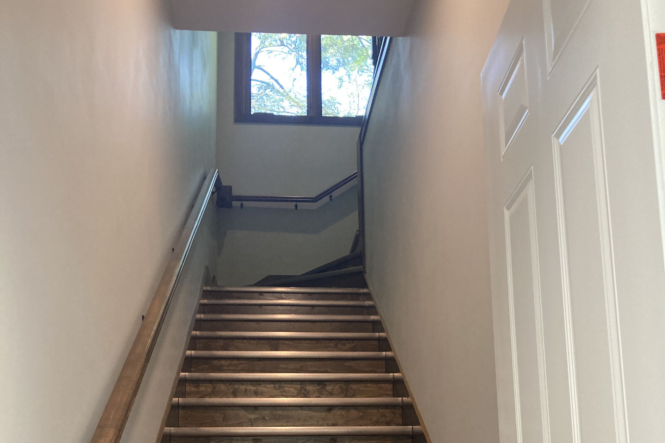 Shop with living quarters staircase with wood steps and window providing natural light
