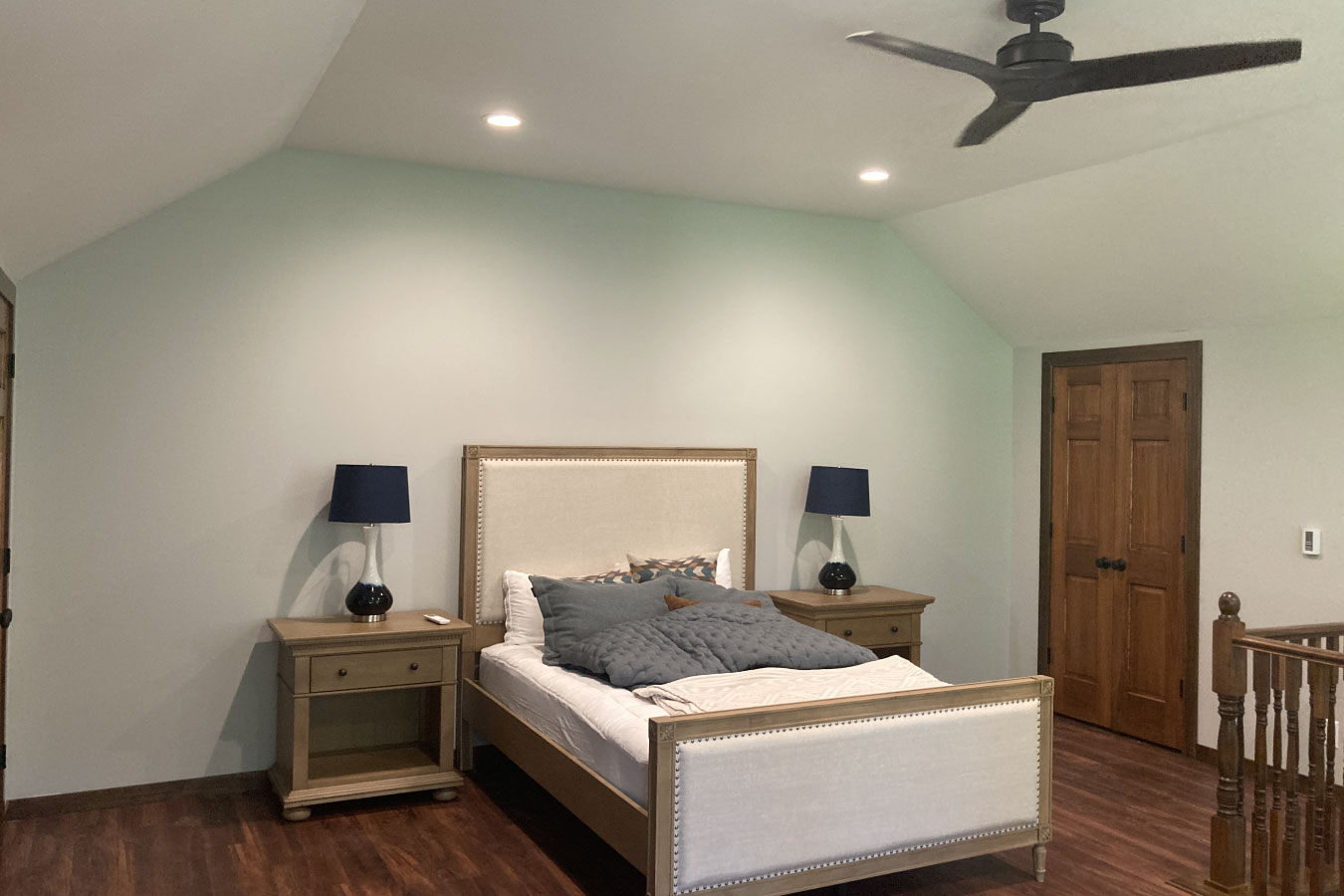 Shop with living quarters bedroom with wood flooring, ceiling fan, and finished interior