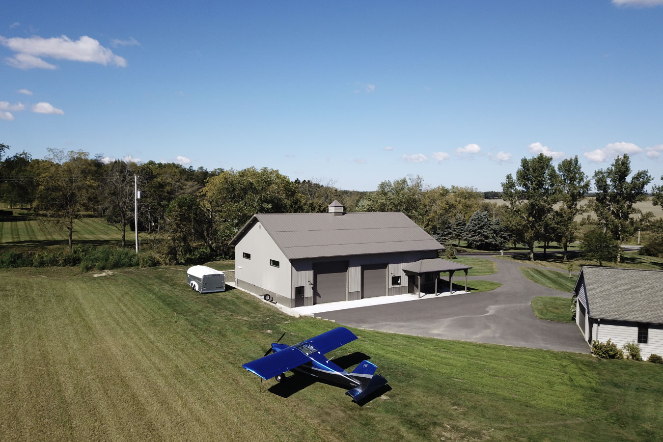 Custom man cave garage on rural property with steel siding and surrounding land