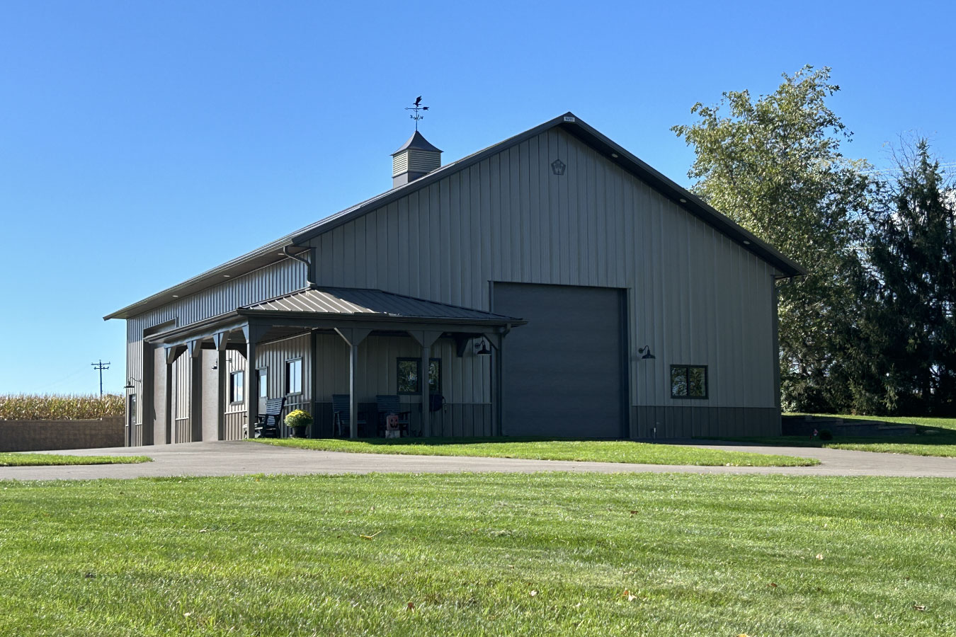 94-0733 Custom man cave garage with steel siding, large overhead door, and covered porch