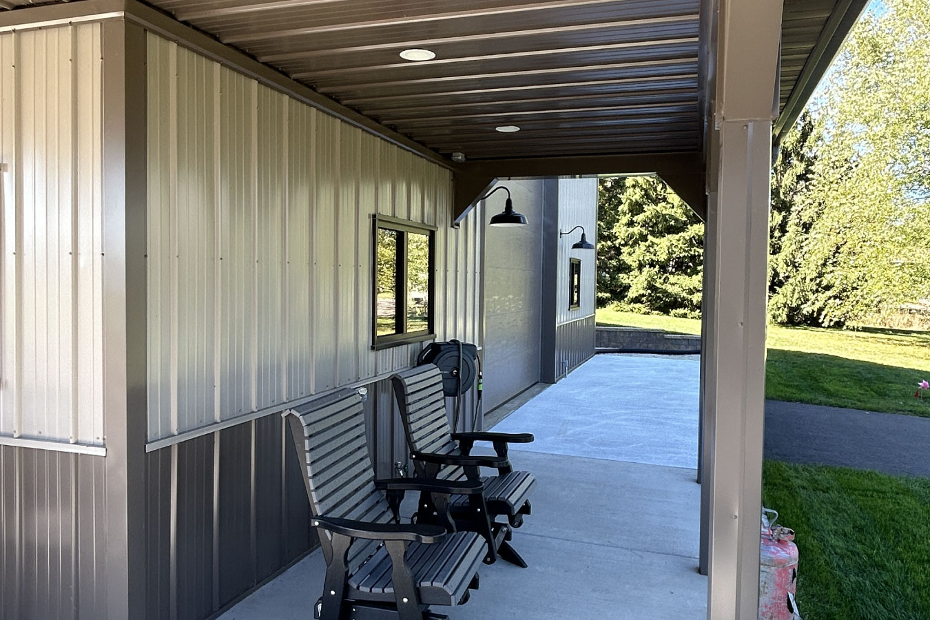 Angled view of custom man cave garage with porch and oversized overhead door