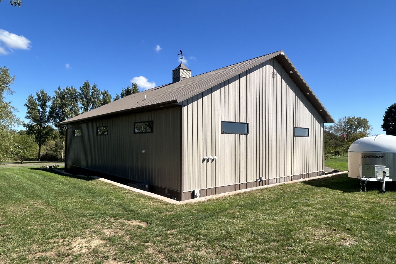 This man cave garage features a covered porch with comfortable seating and exterior lighting, creating a relaxing outdoor space for gathering and unwinding. The porch extends the functionality of the garage beyond storage, making it ideal for entertaining and everyday use.