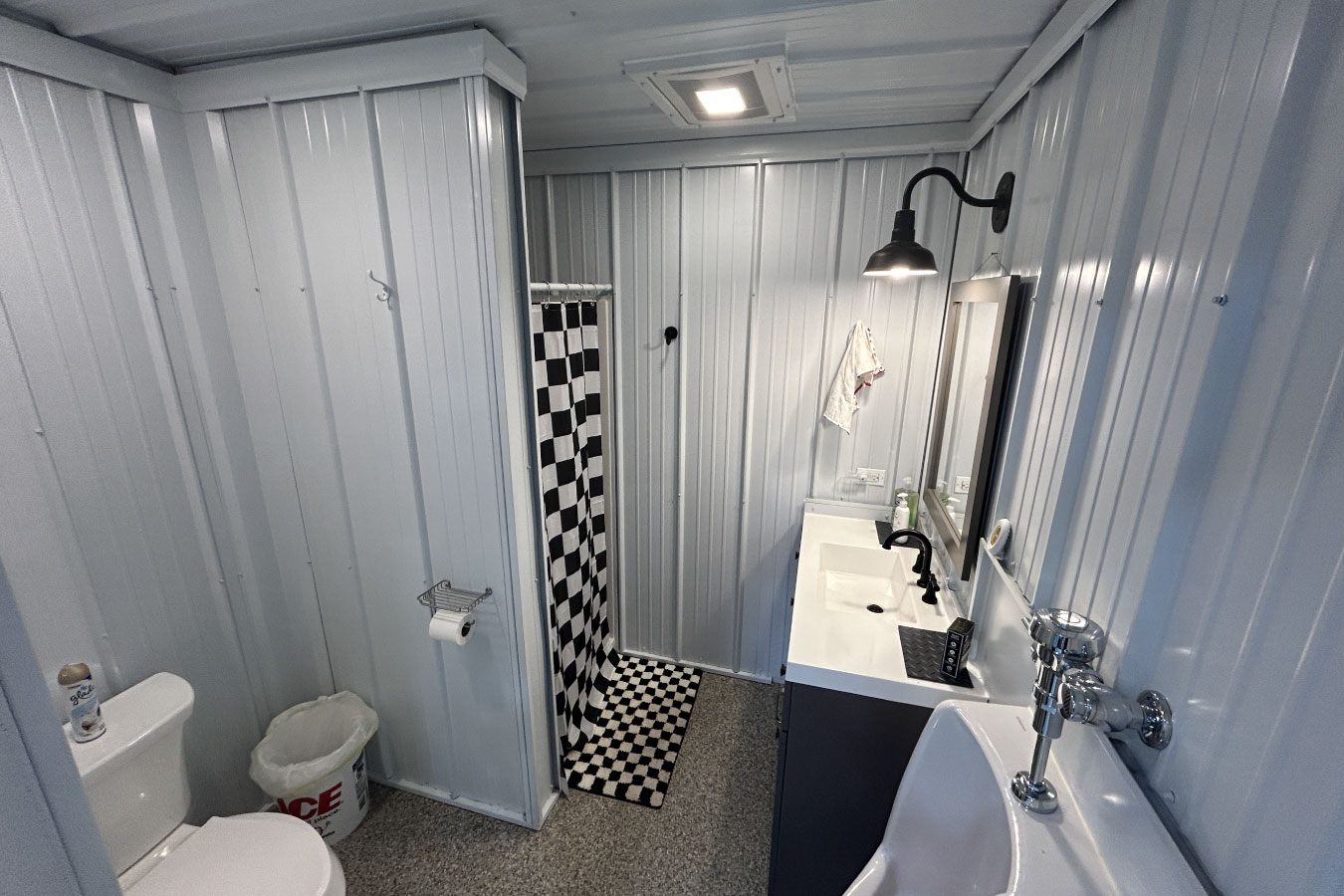 Bathroom with shower and urinal, adding convenience to the Ultimate Man Cave Garage.