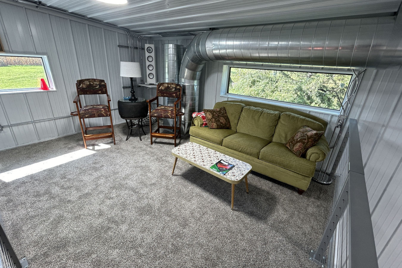 Cozy loft lounge area with vintage seating, perfect for relaxing in the Ultimate Man Cave Garage