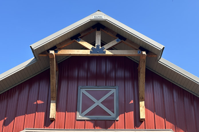 Pole barn workshop gable detail with exposed timber truss and decorative accents