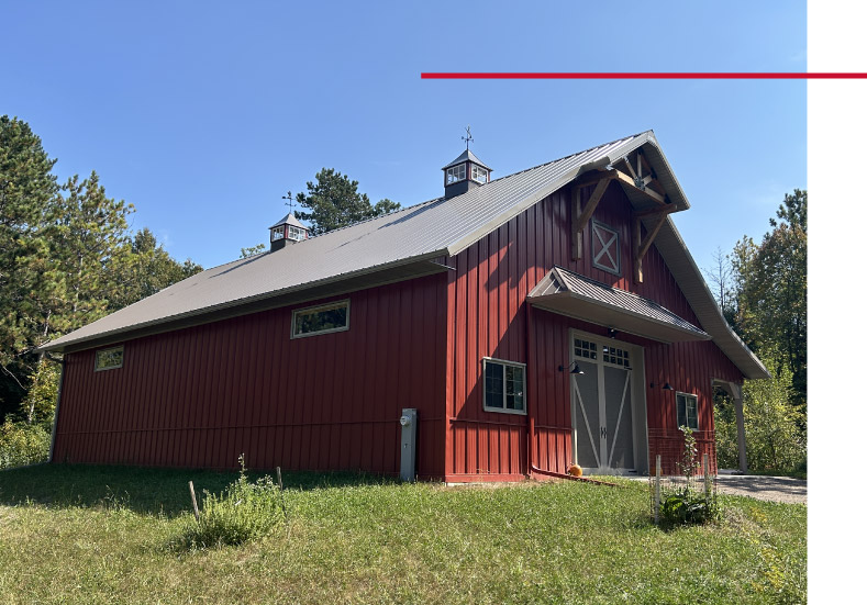 Pole barn workshop with overhead door, cupolas, and gable truss detail