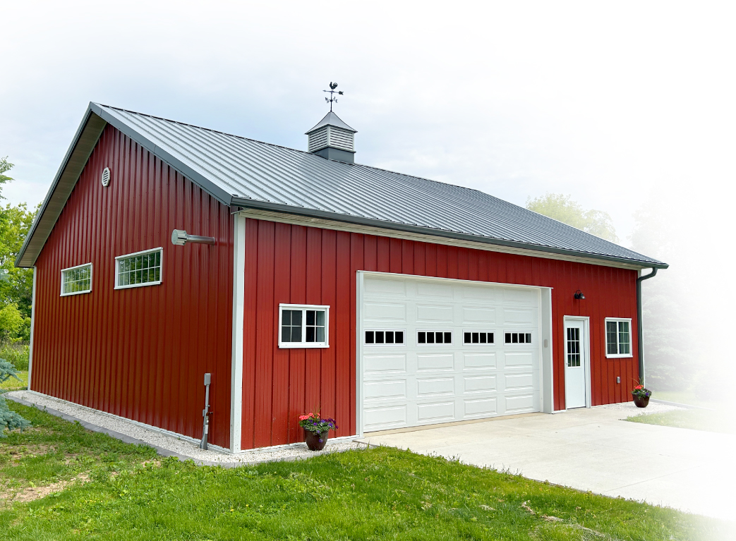 Post-Frame Storage Building Garage with Overhead Door and Cupola Post-frame storage building garage with red steel siding, overhead door, cupola, and concrete driveway