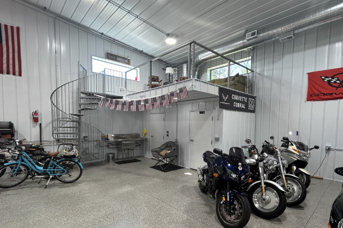 Man cave garage interior with loft, spiral staircase, and motorcycle storage This ultimate man cave garage interior features multiple car lifts for efficient vehicle storage and display, creating a true automotive enthusiast space. With high ceilings, bright lighting, and a wide-open layout, the building is designed to function as both a working garage and a showcase for classic and performance vehicles.