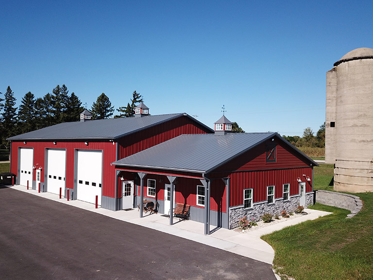 Custom Farm Shop and Equipment Storage Building | Walters Buildings Custom farm building with overhead doors, covered porch, and steel siding designed for equipment storage and shop use