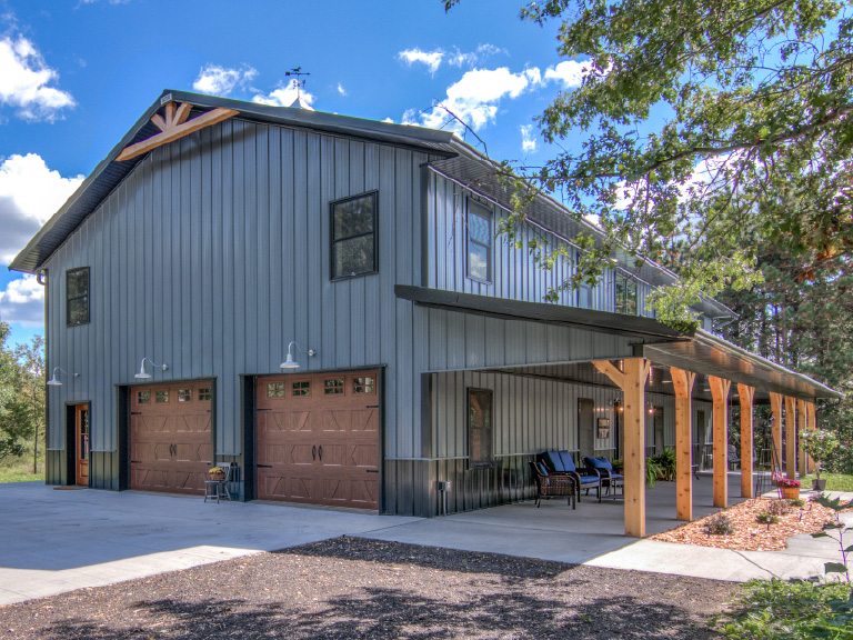 Post frame garage with steel siding, overhead doors, and covered porch