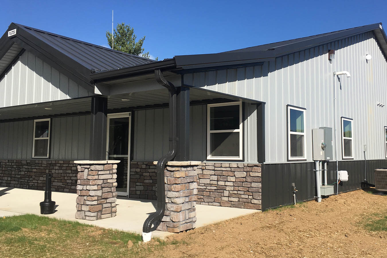 Fire department building entrance with stone column porch and metal siding Front Entrance
