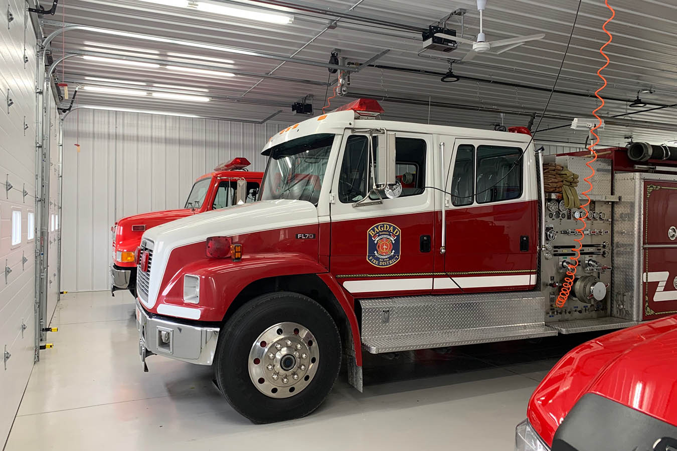 Interior fire department apparatus bay with three overhead doors