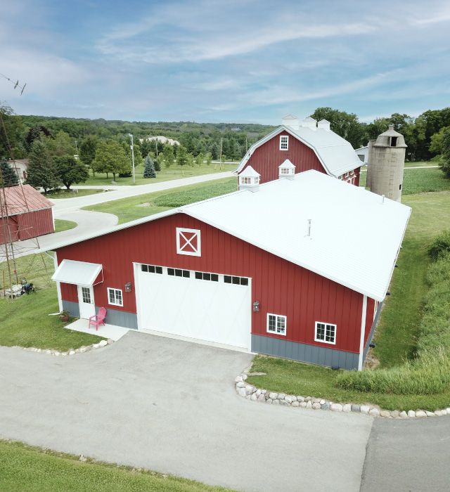 Car Collection Garage with Red Steel Siding | Post Frame Building | Walters Buildings car collection garage with red steel siding, white overhead door, and cupola