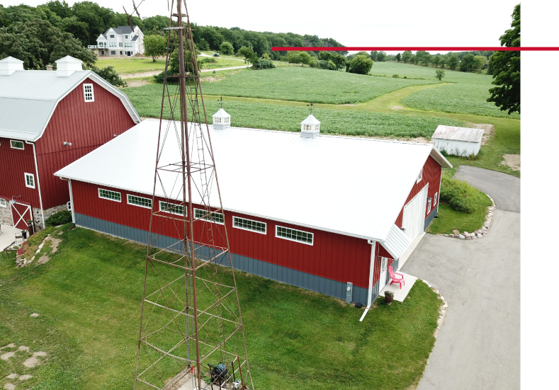 Car Collection Garage with Upper Windows and Cupolas | Post Frame Building | Walters Buildings car collection garage with red steel siding, upper windows, white metal roof, and cupolas