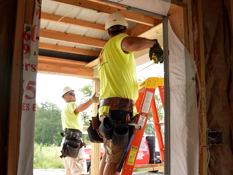 Post-Frame Construction Process – Door Frame Installation Walters Buildings crew installing door frame during post-frame construction process
