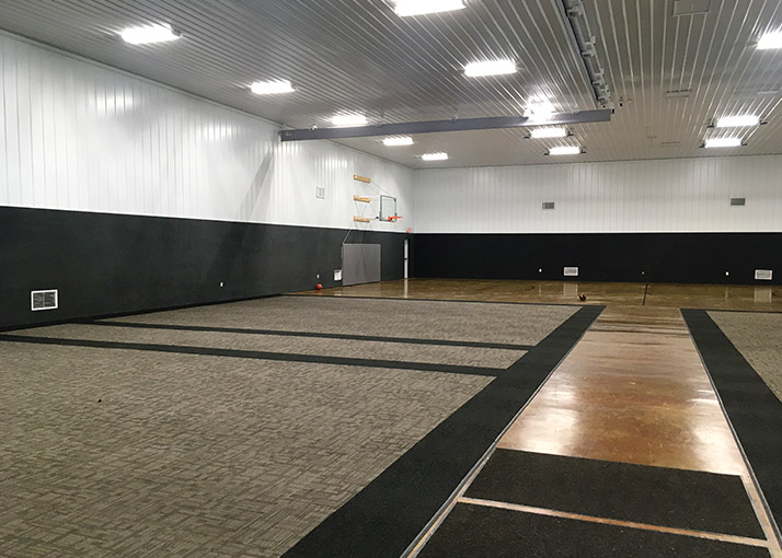 Open-Span Event Space Interior with Steel Liner Panels Interior of post frame event space with steel liner panels, open-span layout, and sports court flooring for multi-use events