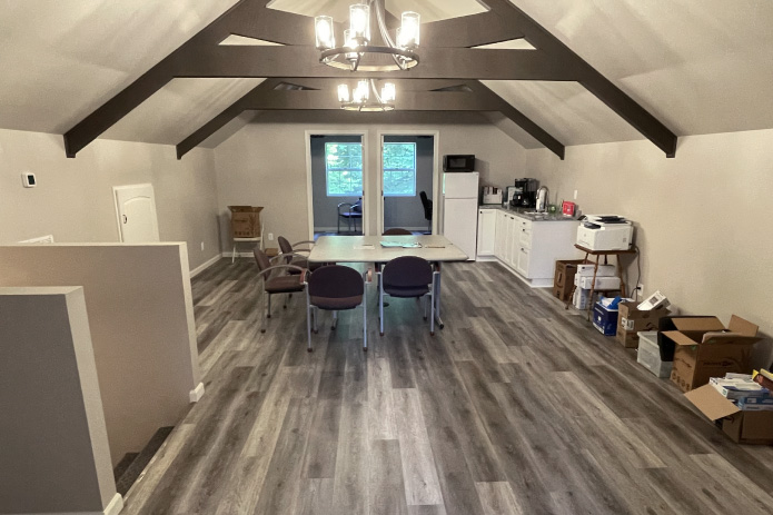 Garage with Living Quarters Interior | Post Frame Loft with Exposed Beams | Walters Buildings garage with living quarters interior loft featuring exposed beams, wood flooring, and kitchenette