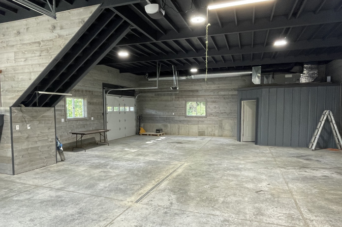 Garage with Living Quarters Interior | Post Frame Garage with Open Floor Plan | Walters Buildings garage with living quarters interior showing open garage space, staircase, and post frame construction