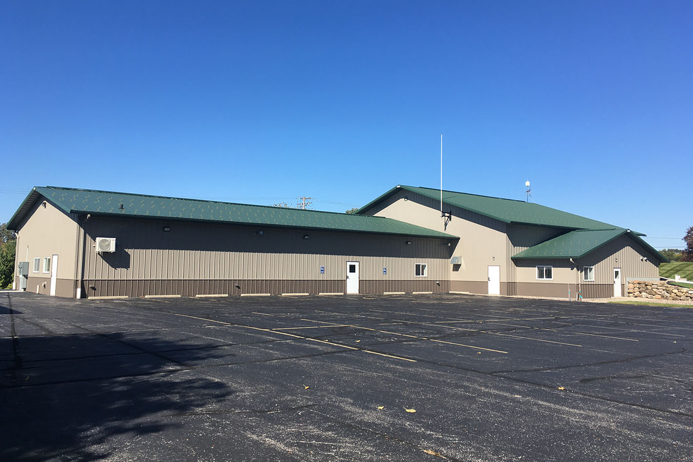 Kohlsville Fire Department post frame fire station with green metal roof and parking lot mason and Steel Wainscot around the Station