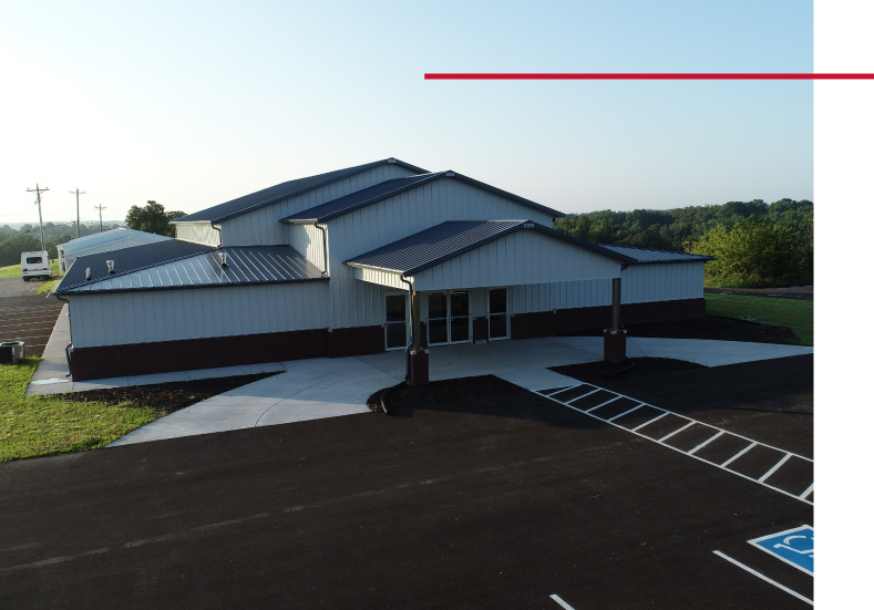 Modern Church Building with Metal Roof and Covered Entrance Modern church building with metal roof, white steel siding, covered entrance, and paved parking lot