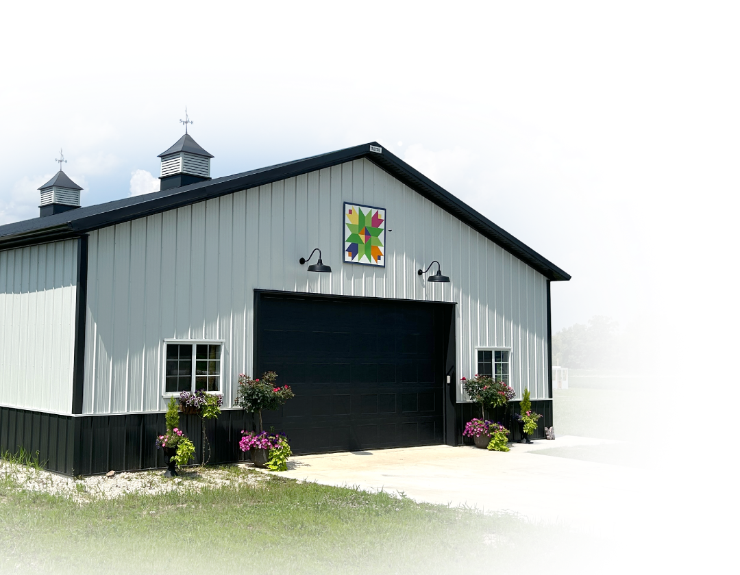 Post-Frame Garage with Overhead Door, Cupolas, and Decorative Steel Exterior Post-frame garage building with steel siding, large overhead door, cupolas, and decorative exterior accents