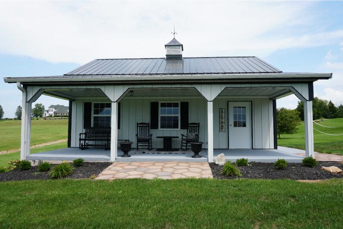 Pole Shed with Covered Porch and Metal Roof | Post Frame Garage Building | Walters Buildings front view of pole shed with covered porch, white siding, black trim, metal roof, and cupola