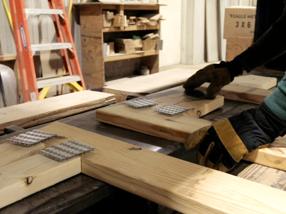Walters Buildings worker assembling wood truss components with metal connector plates