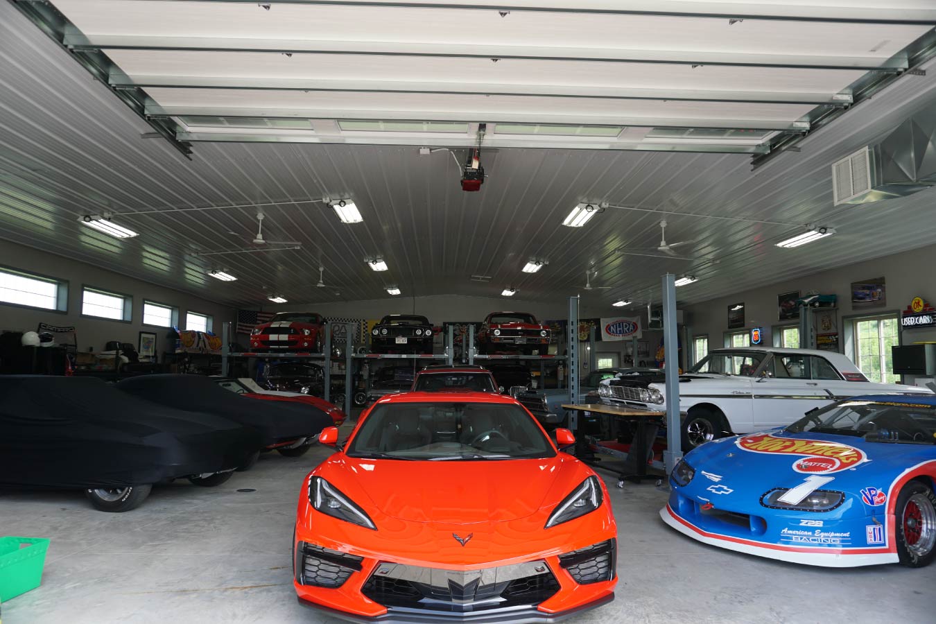 car collection garage interior with multiple vehicles, car lifts, and open post frame layout
