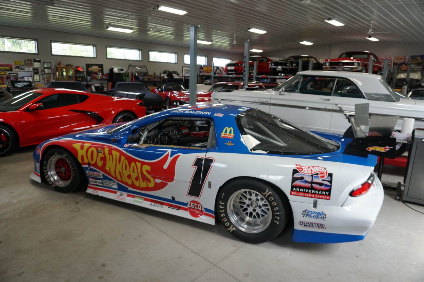 car collection garage interior with race cars, classic cars, and vehicle lifts