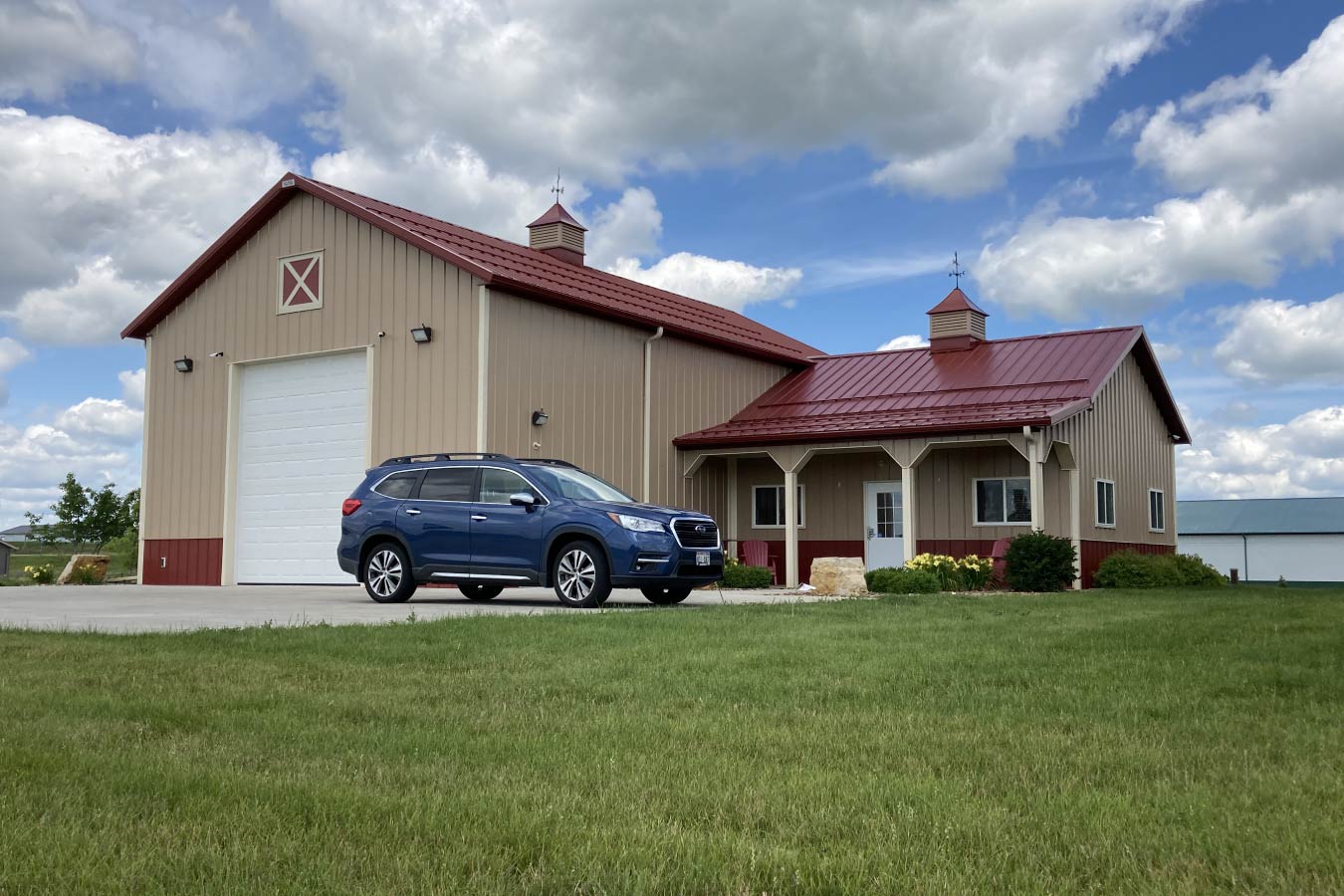 95-1138 Storage Condo with Office Addition, overhead door, covered porch, walk door, and red steel roof with cupolas