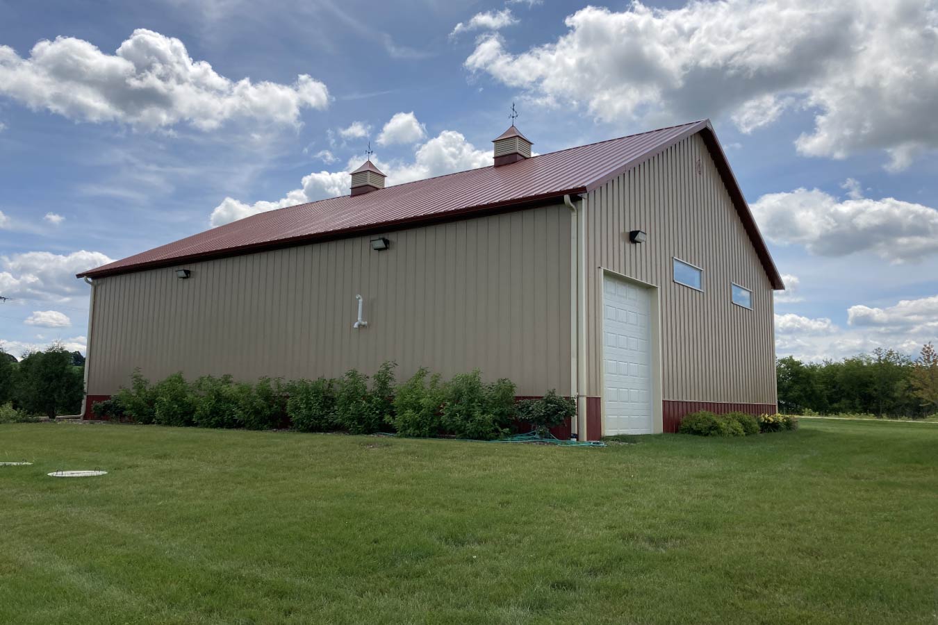 Commercial storage condo building side view with overhead door, cupolas, and upper windows