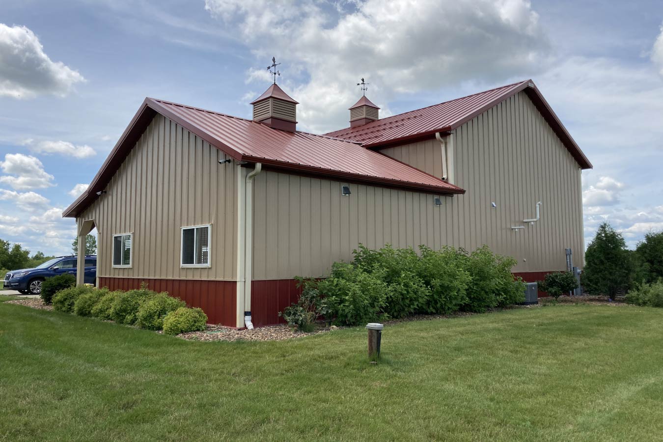 Commercial storage condo with office addition, windows, cupolas, and landscaped exterior