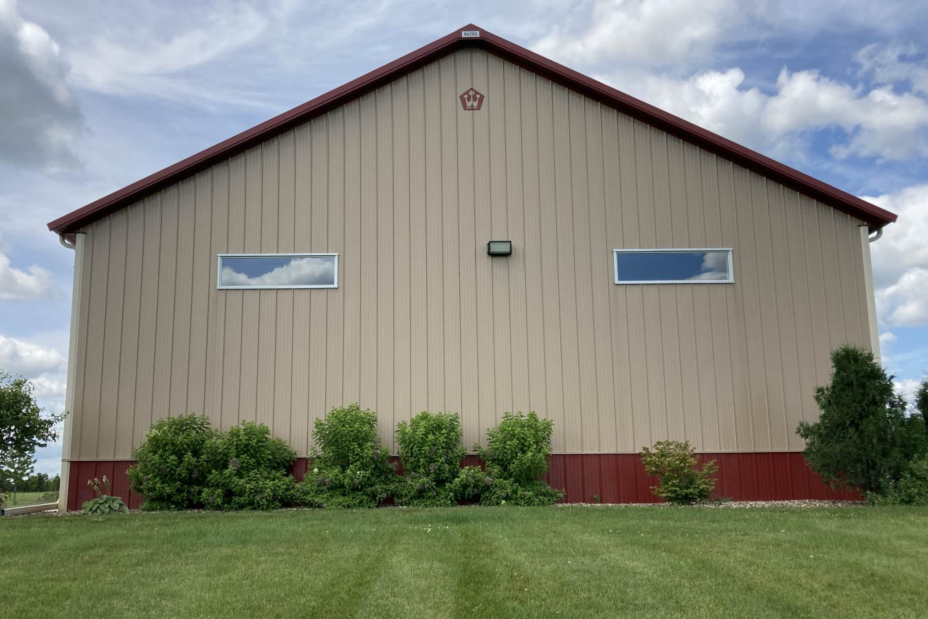 Commercial storage condo endwall with upper windows, steel siding, and landscaped base