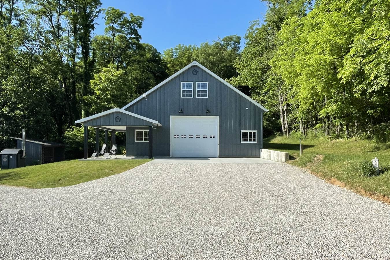74-0480 garage with living quarters featuring steel siding, covered porch, and large overhead garage door