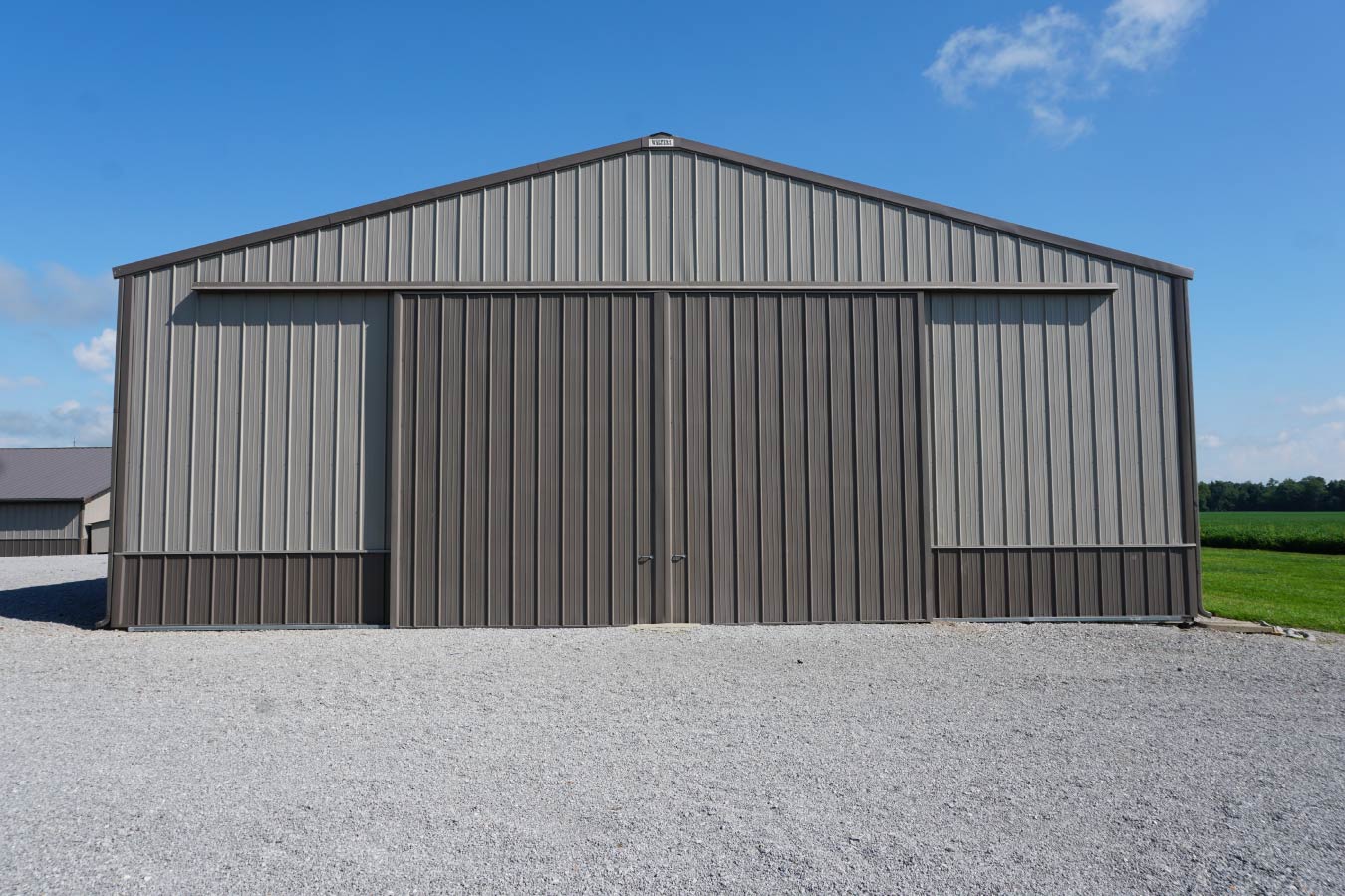 Grain farm pole barn used as an agricultural storage building with large sliding equipment doors Dual Sliding Doors on Storage Building