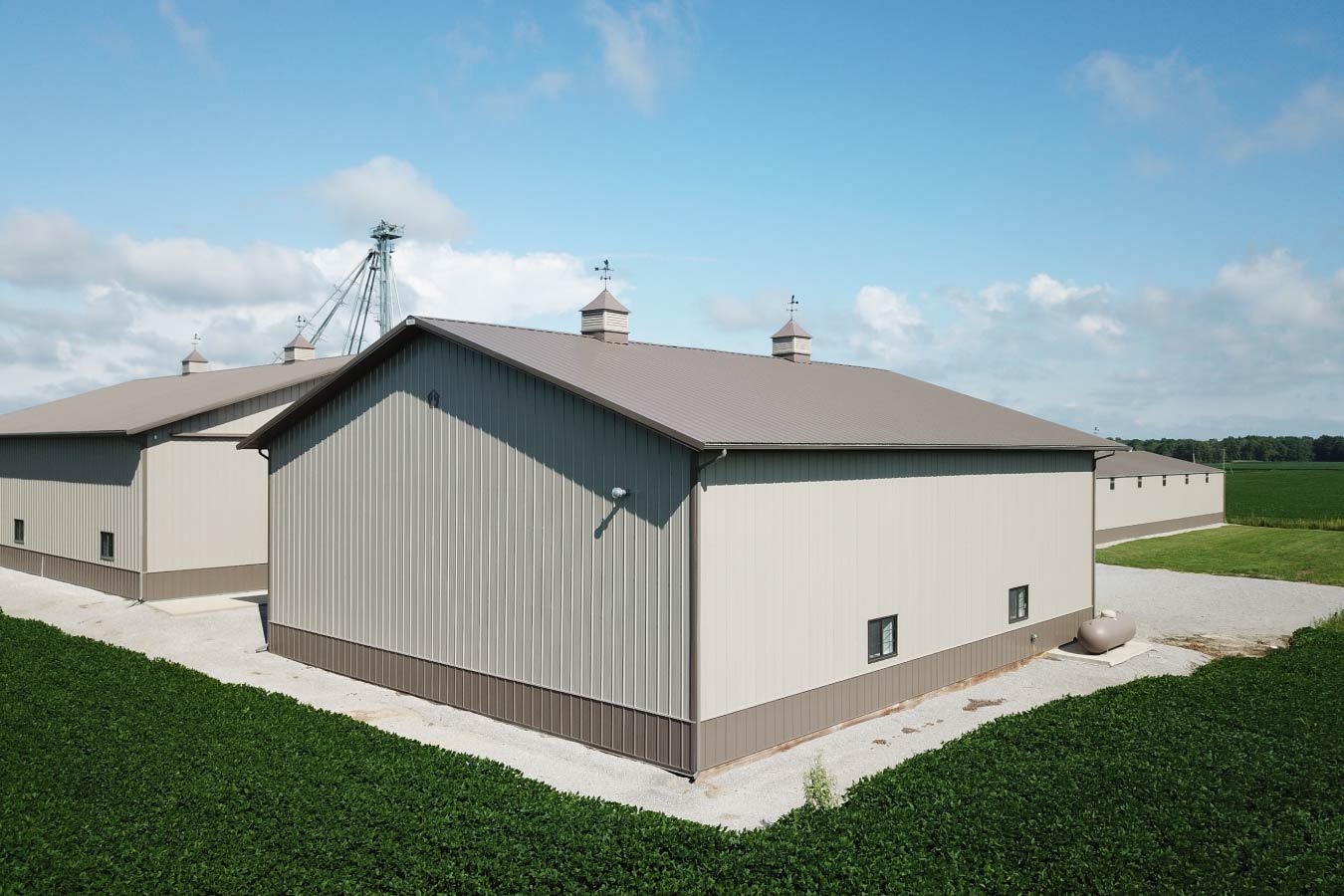 Back View of agricultural pole barn used as a farm equipment storage building beside crop fields