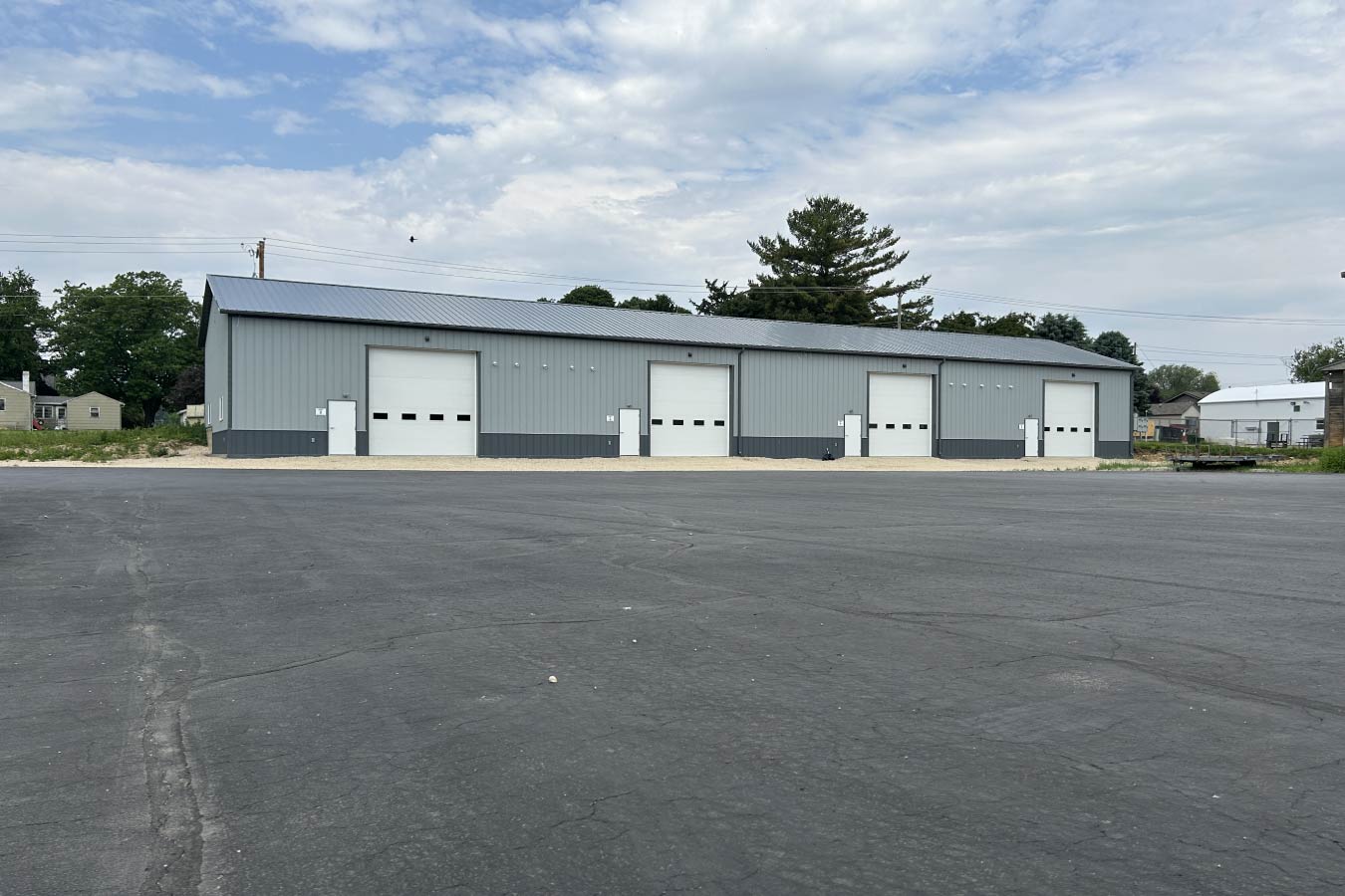 95-1945 Hustisford Business Condos building with multiple commercial units and overhead garage doors on large asphalt lot