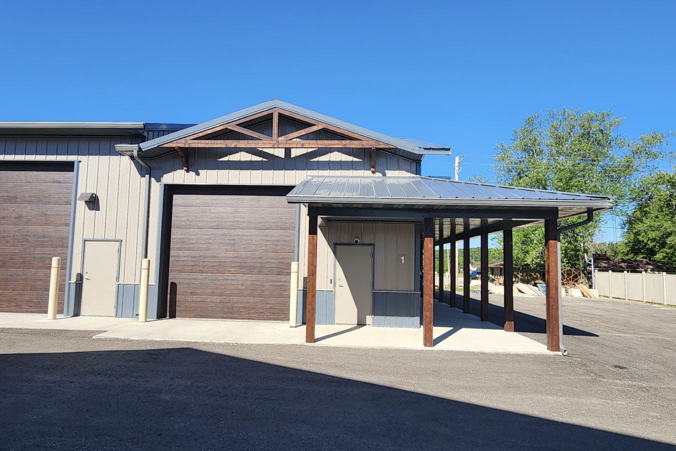 storage condominiums unit with large garage door covered entry and wood post porch