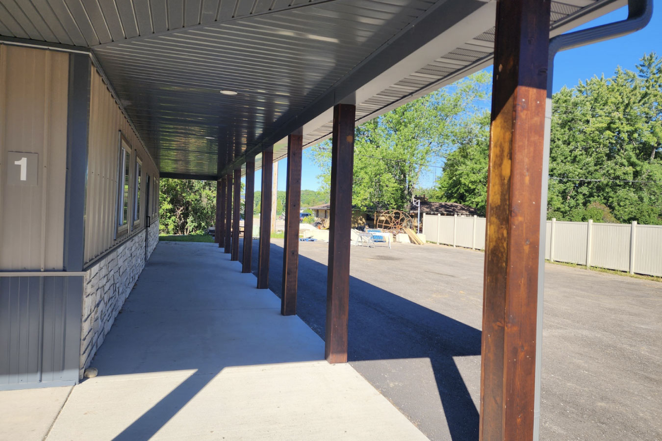 storage condominiums covered walkway with wood posts and concrete entry