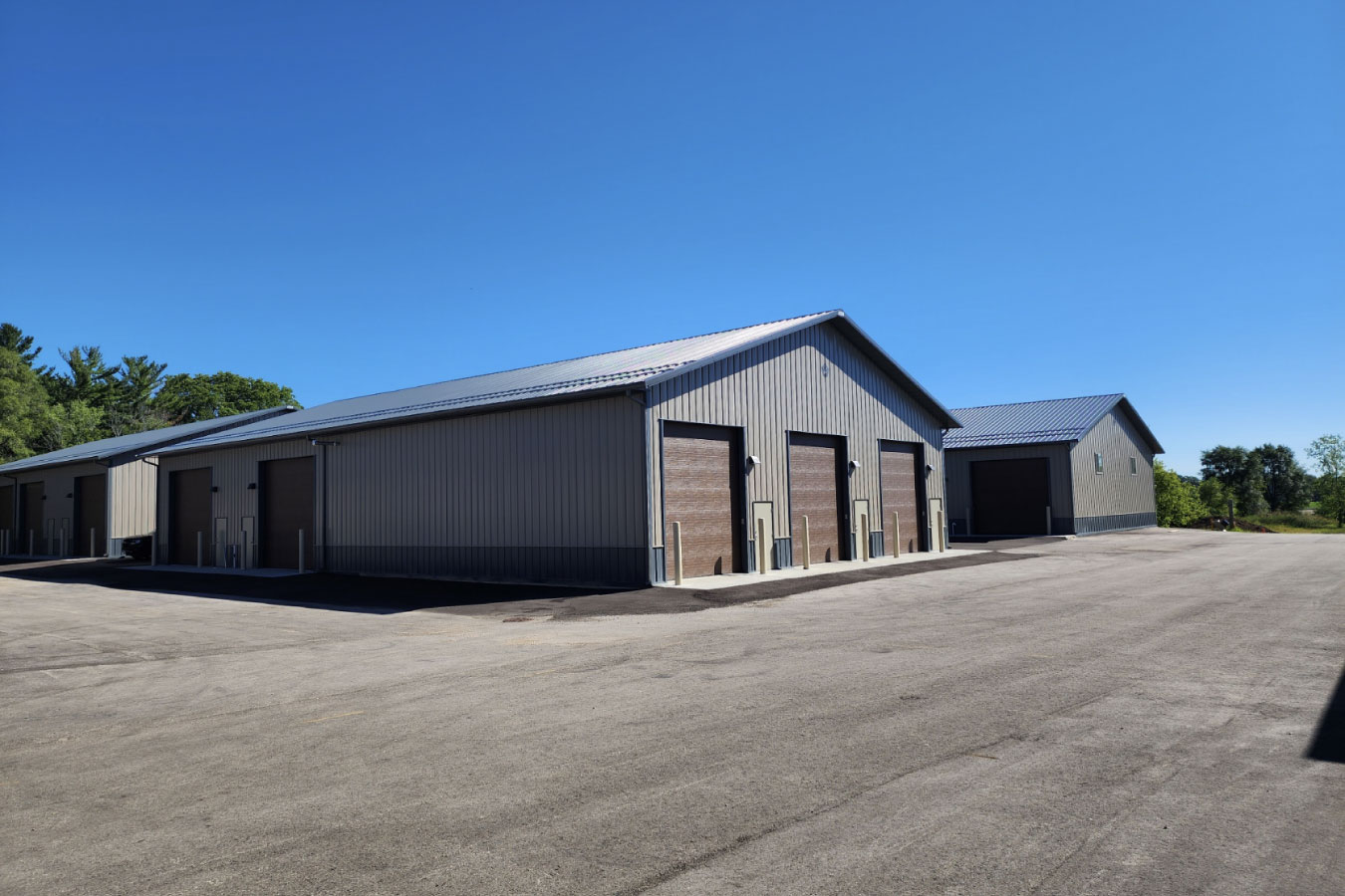 storage condominiums complex with multiple buildings and overhead garage units on large paved lot