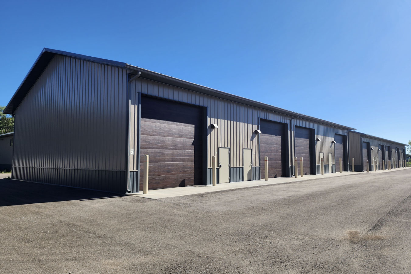 row of storage condominiums units with large overhead garage doors and paved driveway