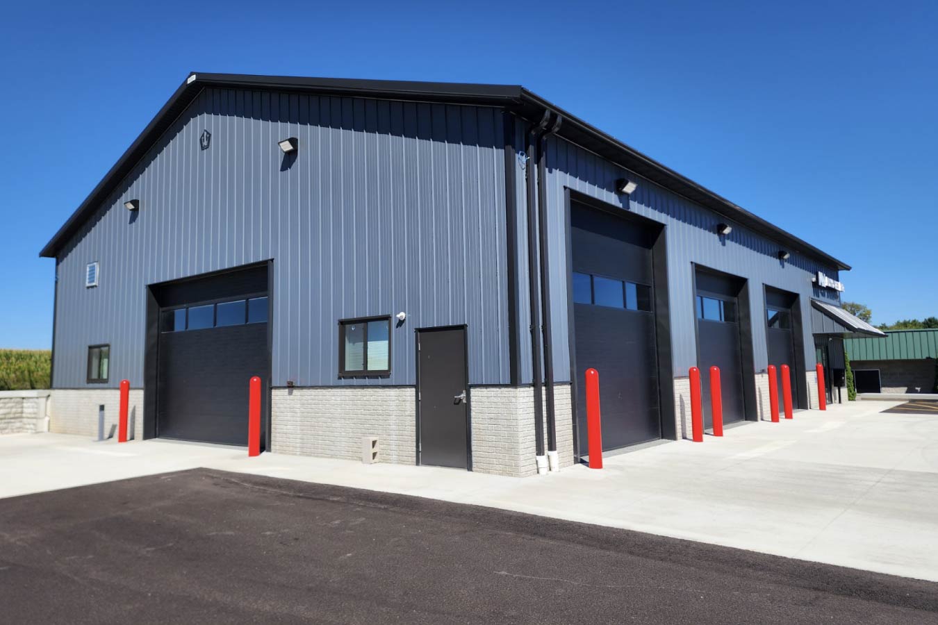 MW Auto Repair auto repair shop with multiple overhead garage doors Charcoal Steel Siding with Black Steel Trim