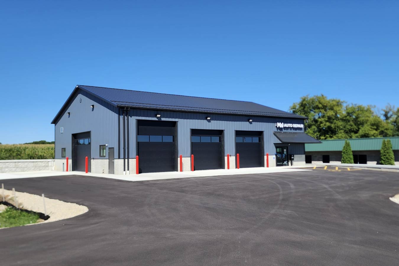 post-frame auto repair shop building with multiple garage service bays Oversized Door on Side Wall for Large Trucks