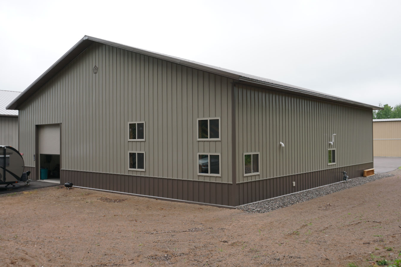 airport hangar with steel siding overhead door and windows in rural setting