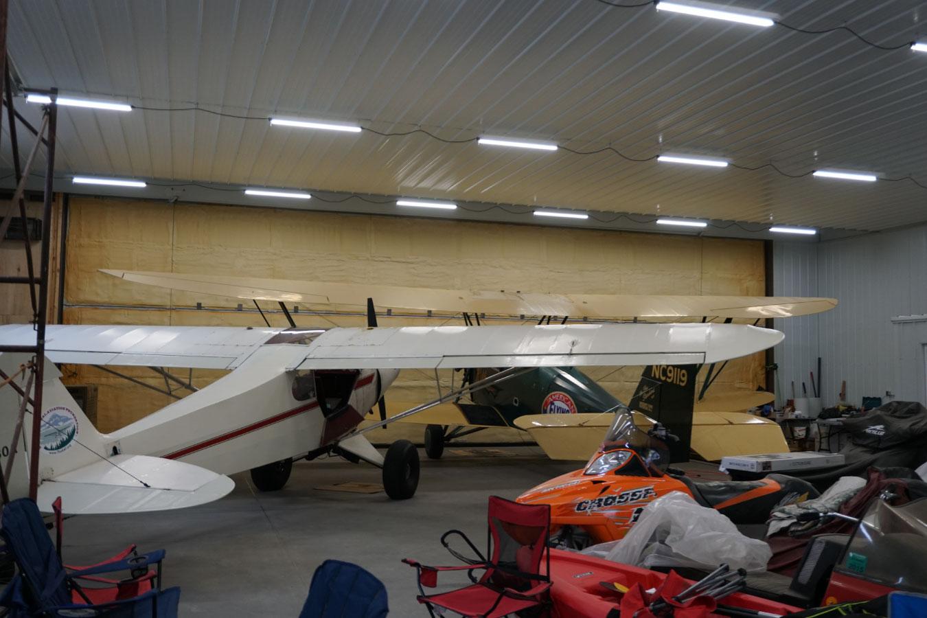 airport hangar interior with airplanes stored inside and bright overhead lighting