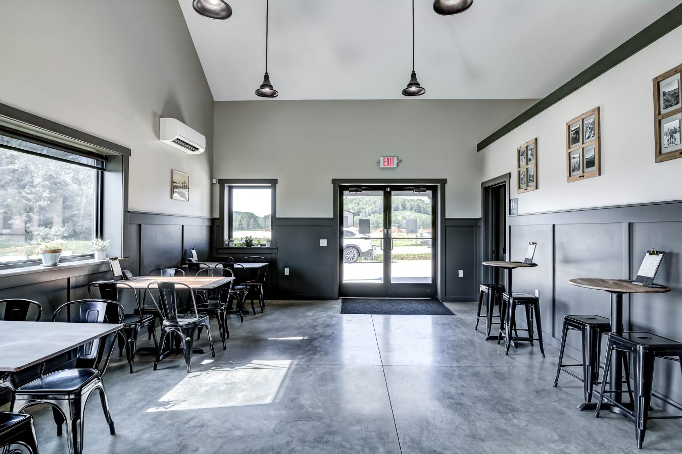 commercial building interior tasting room with seating tables polished concrete floor and large windows