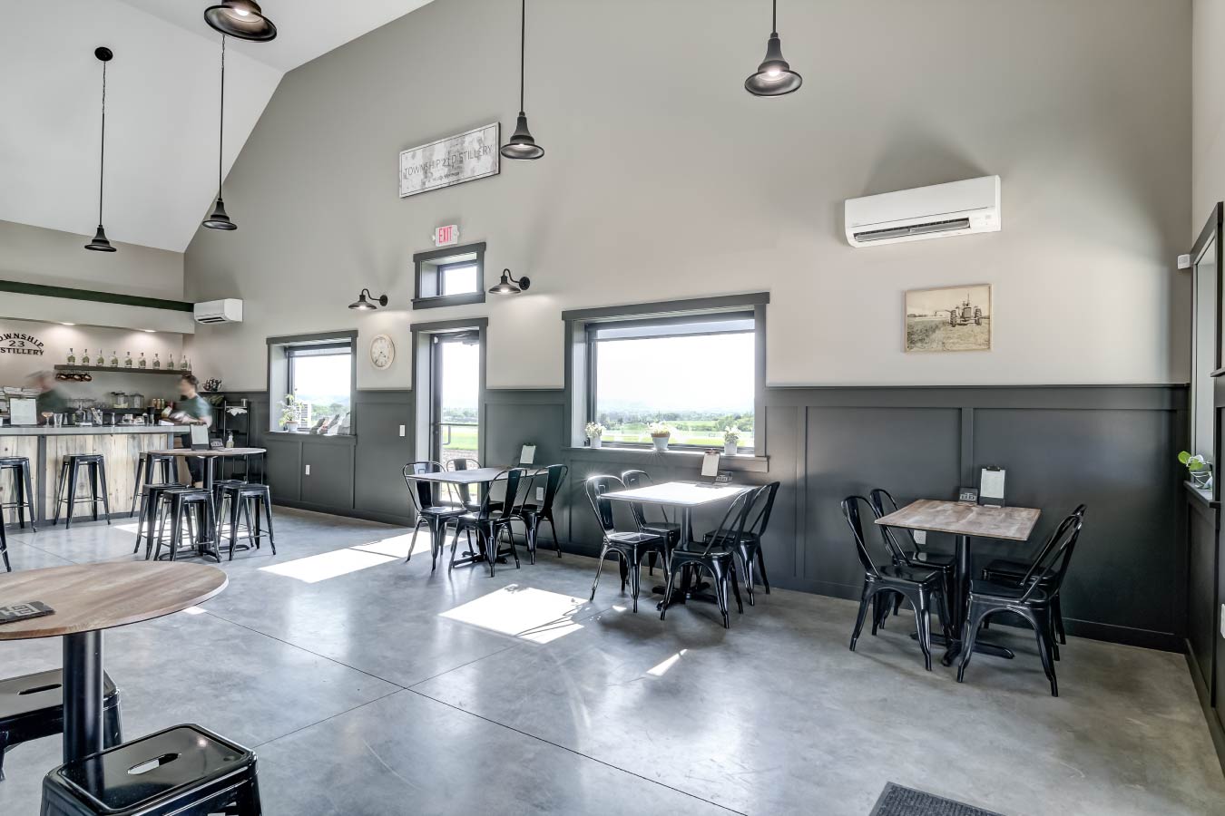 commercial building interior tasting room with seating tables polished concrete floor and large windows